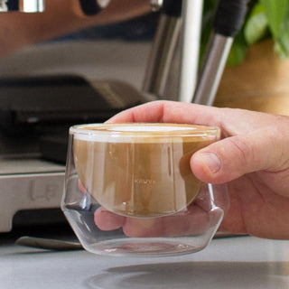 KRUVE IMAGINE Glasses (2-Pack) showing double-walled borosilicate glass with latte inside held by hand