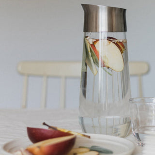 KINTO LUCE Water Carafe with stainless steel lid holding infused water with apple and cucumber slices