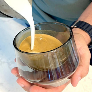 KRUVE IMAGINE Glasses (2-Pack) with hand-blown borosilicate glass holding coffee and milk being poured